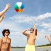a group of people playing with a ball at the beach