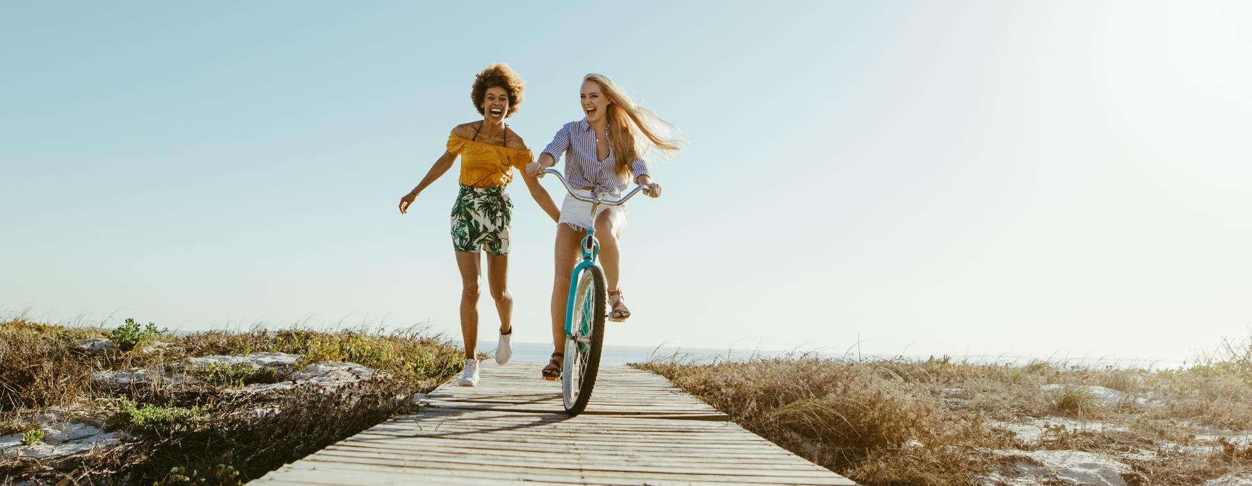 a person riding a bike next to a person walking beside them