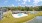 a building with a pool and a swimming pool by a beach